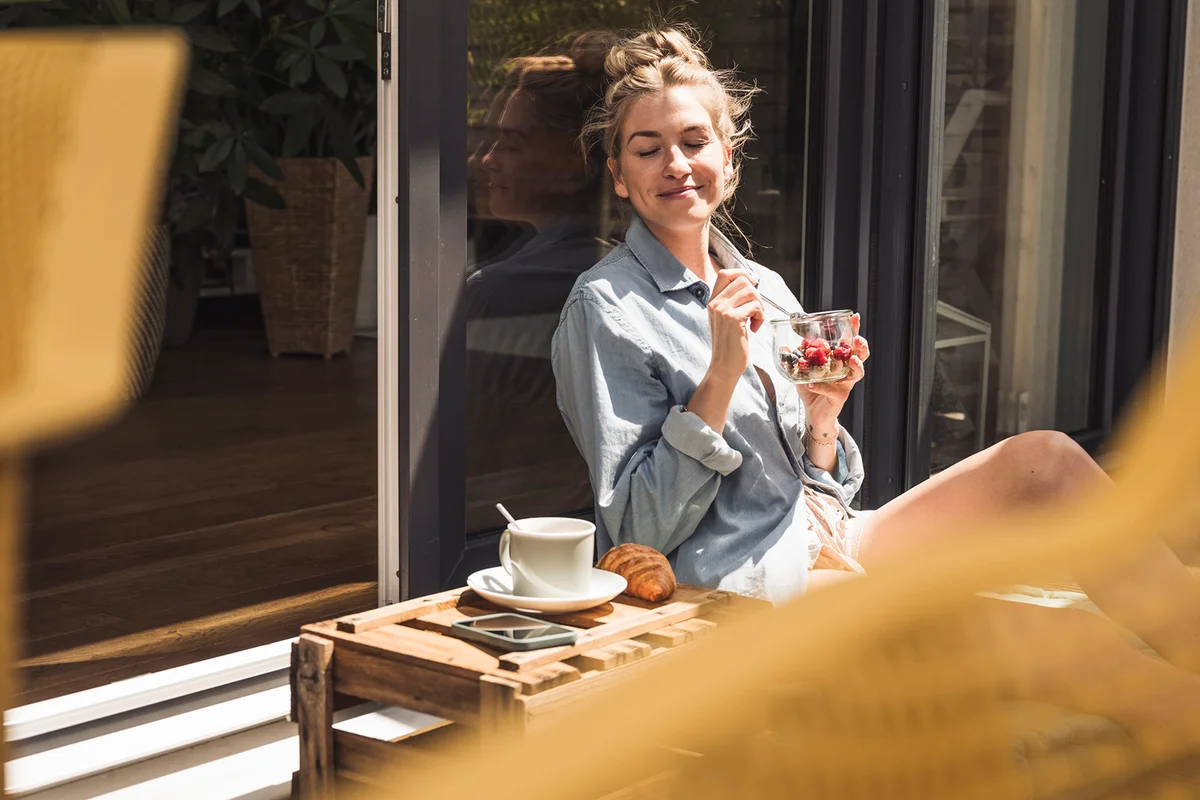 woman enjoying dessert on balcony