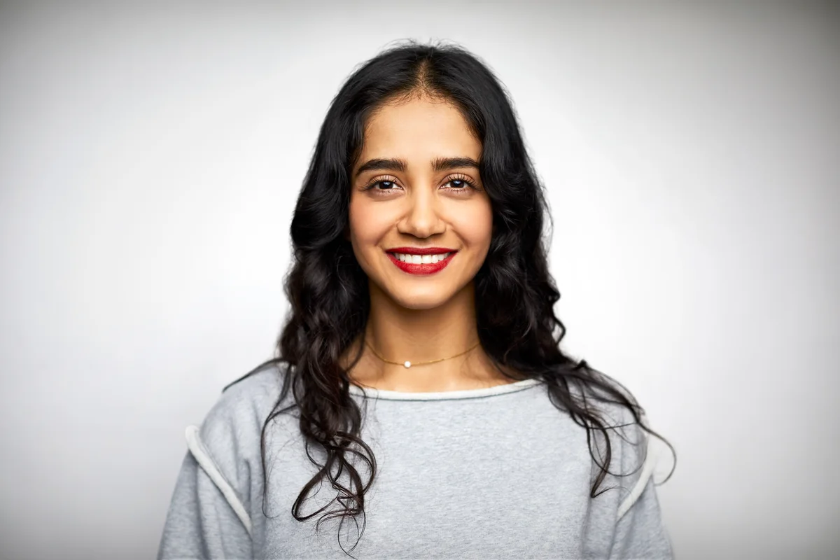 Young woman smiling against white background