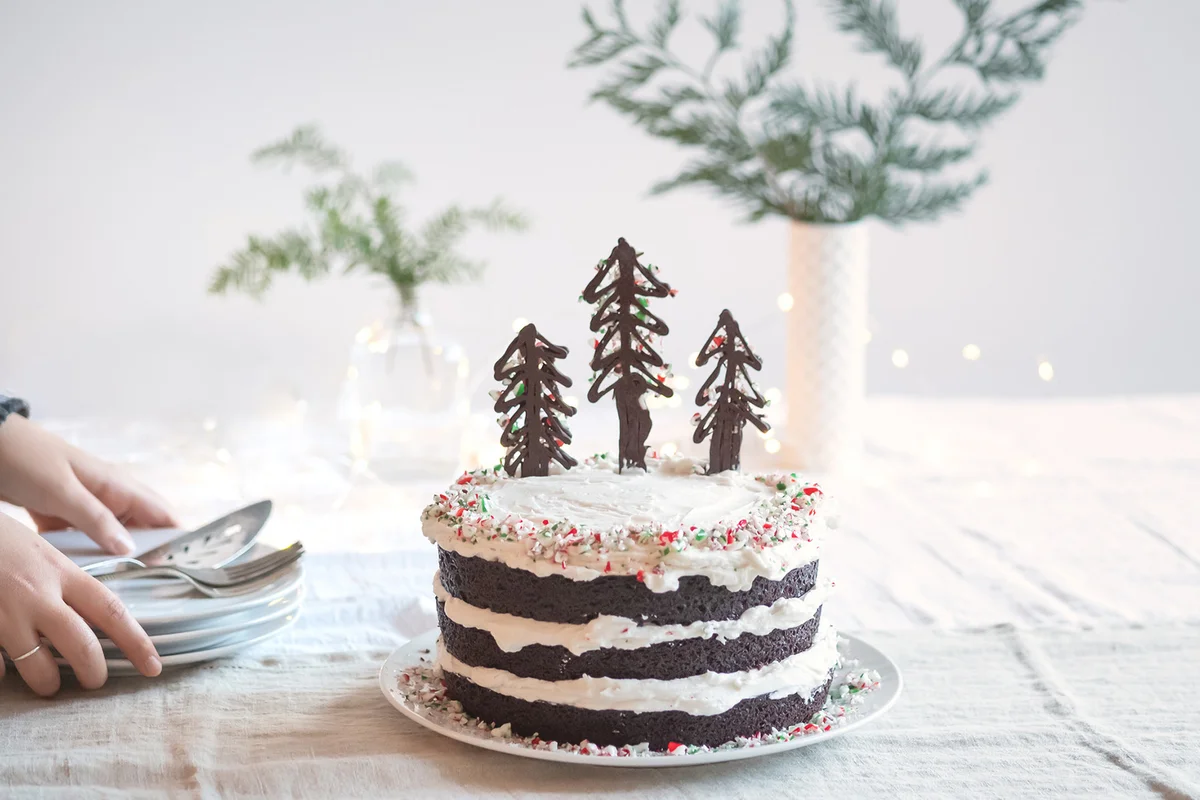 Woman Setting Down Plates for Vegan Christmas Tree Cake