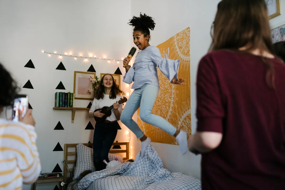 Jumping in the air while singing into hairbrushes at slumber party