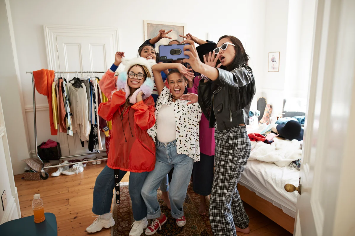 Cheerful female friends gesturing while taking selfie