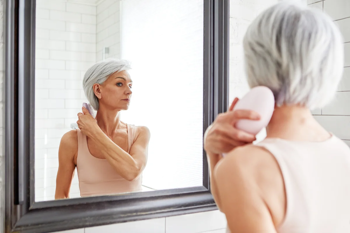 Adult beautiful woman combing her hair