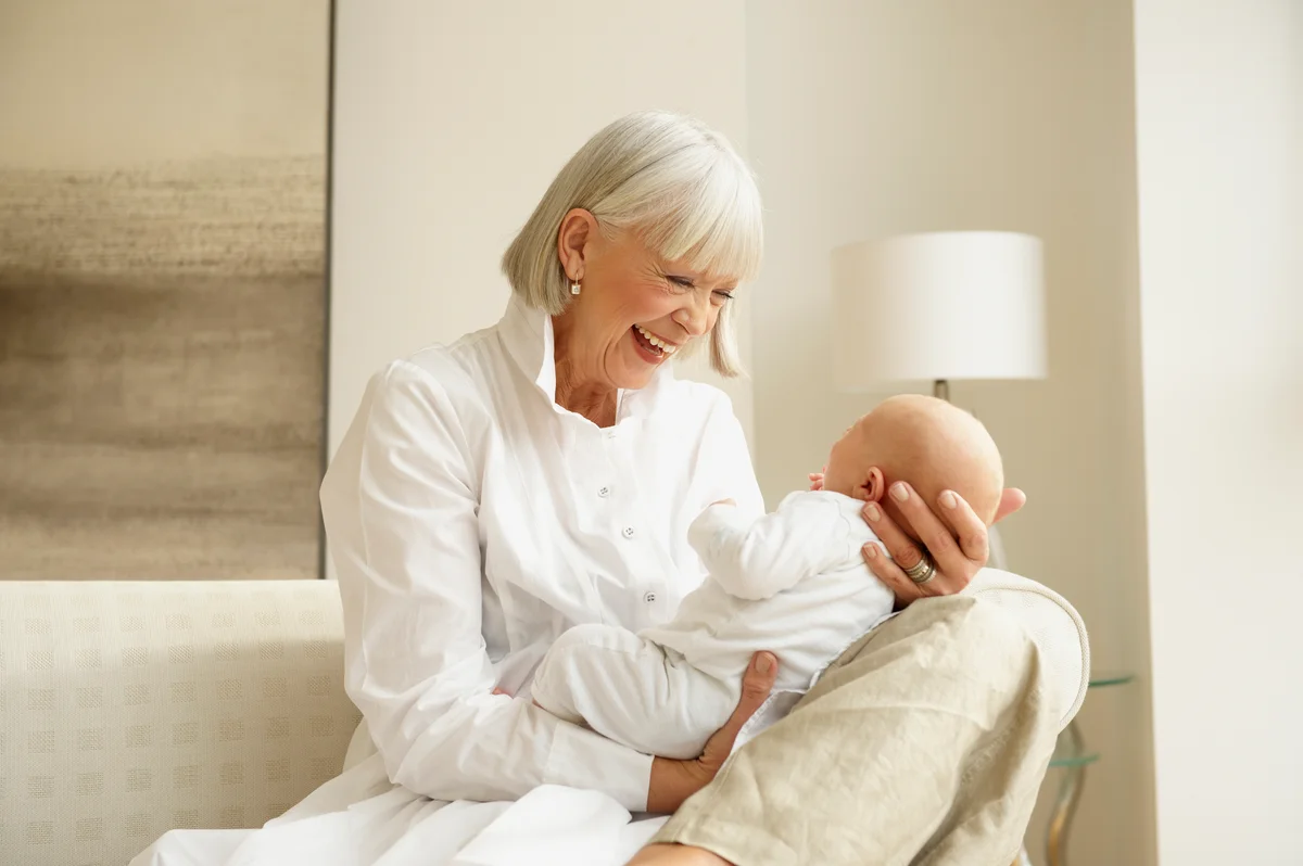 Smiling Grandmother Holding Infant Grandson