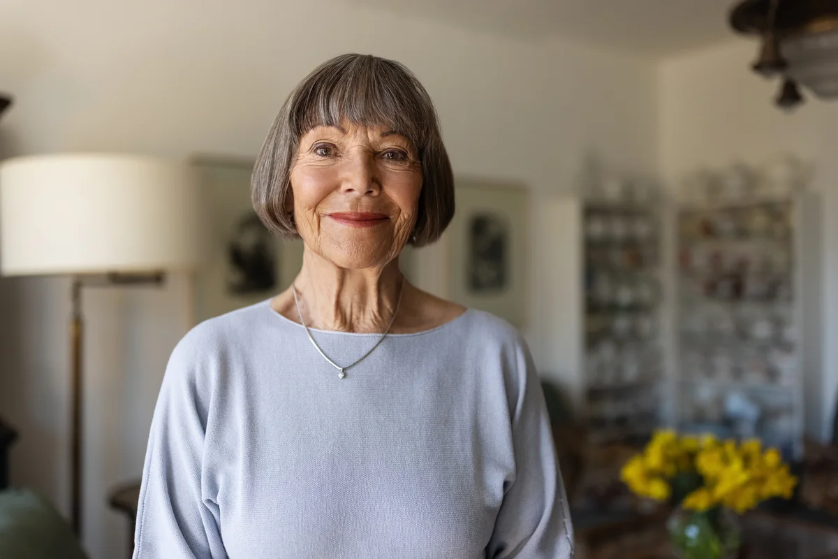 Portrait of a happy senior woman standing in her home