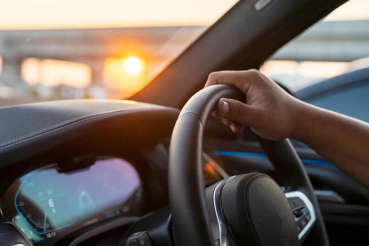 Hand of man driving car on the road