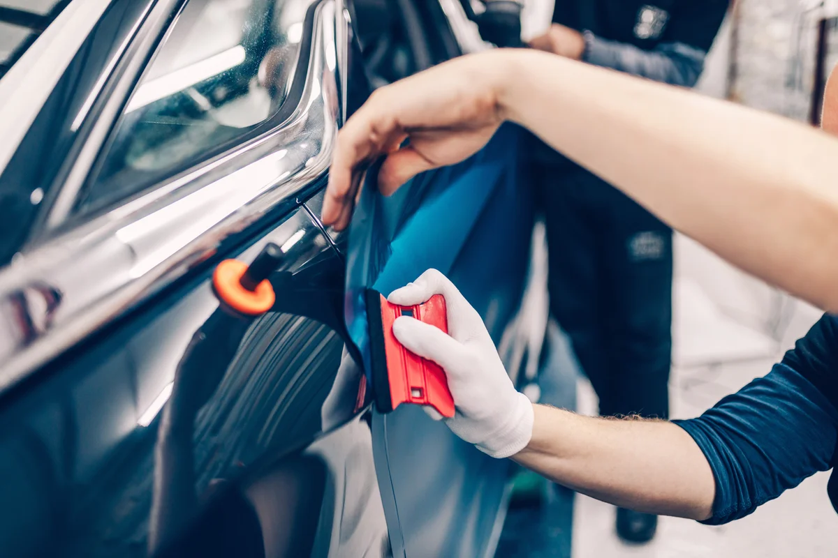 Car wrapping specialist putting vinyl foil or film on car
