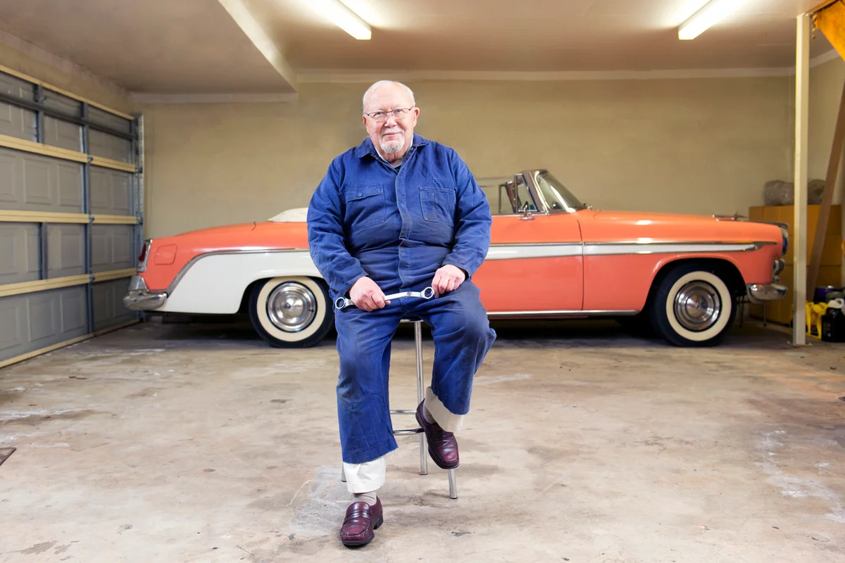 Senior man with classic vintage car in garage