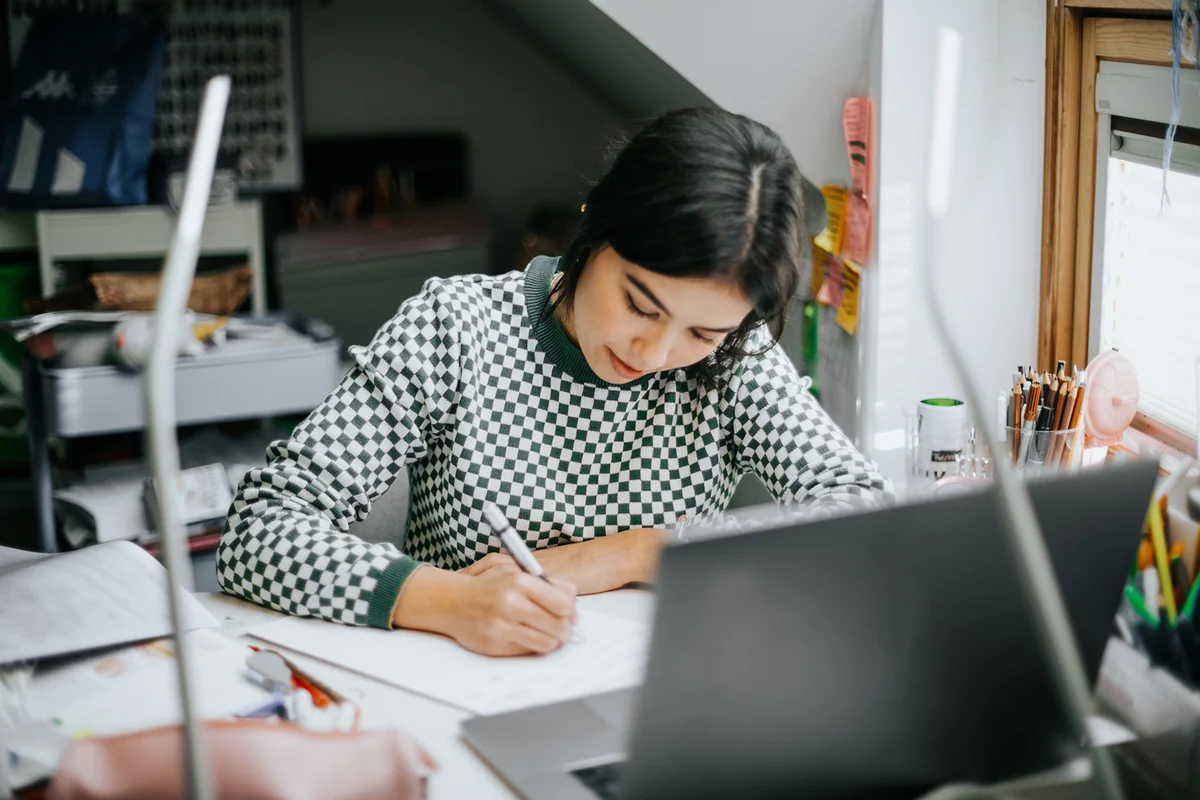 college student doing some home works from home with laptop