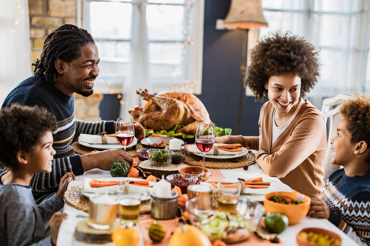 Happy family communicating while having Thanksgiving lunch in dining room