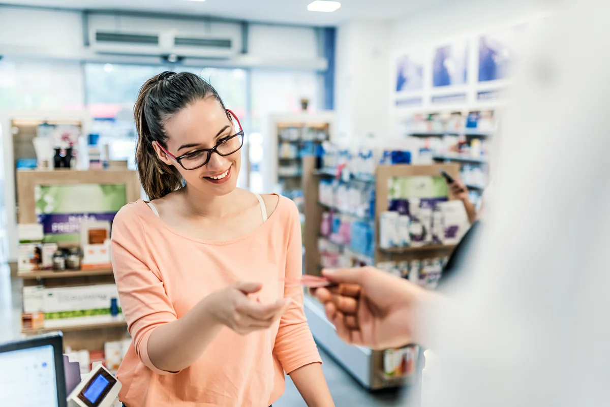 woman with debit card at drugstore