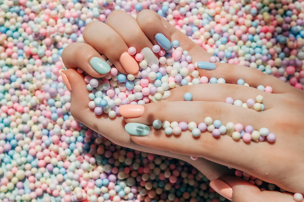 Female hands with colorful polish nails.