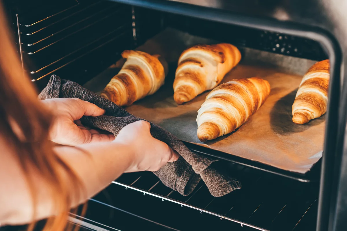 taking a pan of crescent rolls out of the oven