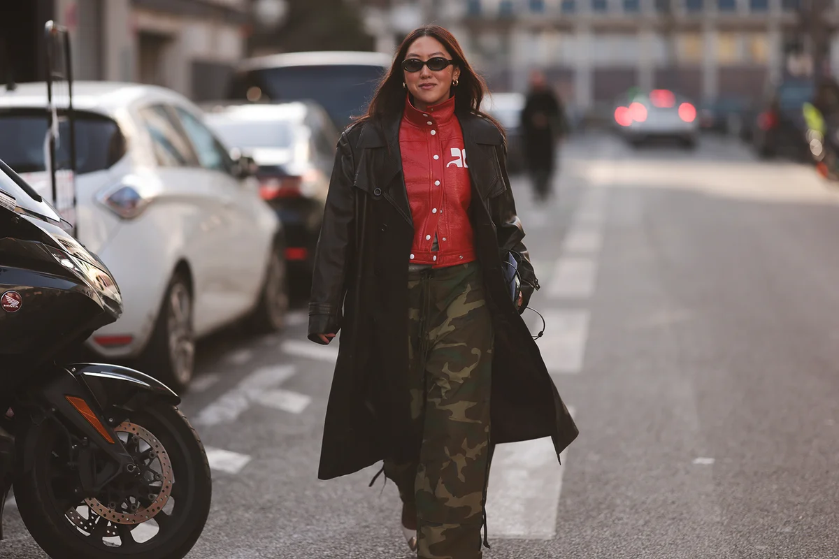 red leather jacket by Courreges, a black bag, a black leather coat, camouflage printed pants