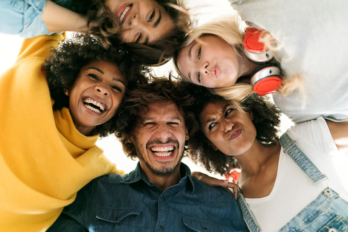 Group portrait of cheerful friends huddling