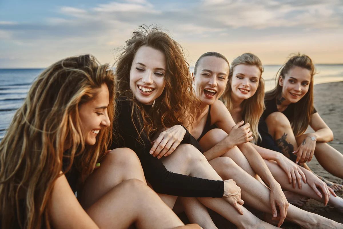 Group of the young women relaxing together next to the ocean
