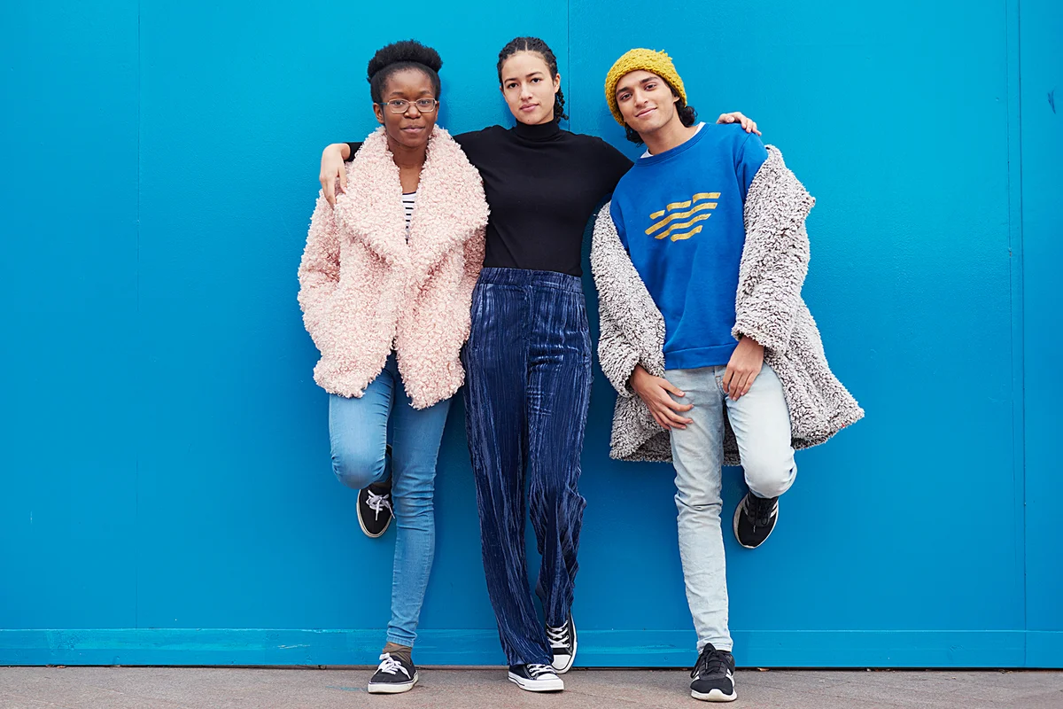 Portrait of three friends against blue background