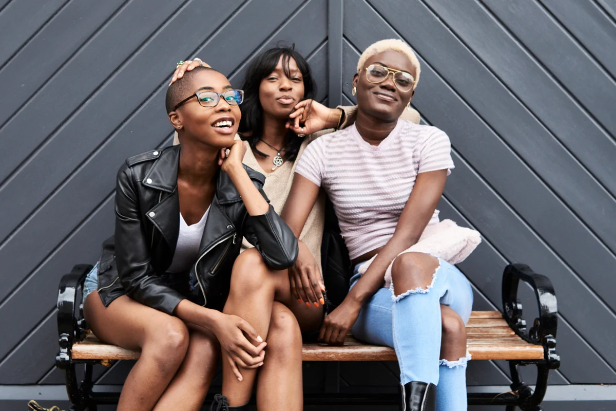 Three friends sitting together on a bench