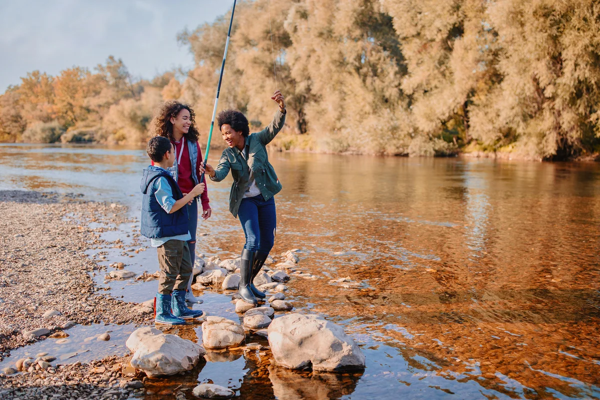 Smiling family fishing by the river