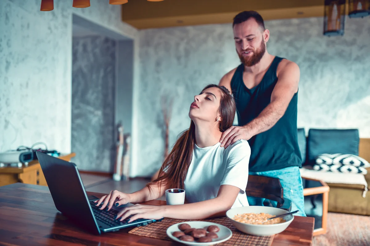 Woman getting a massage from boyfriend while working from home