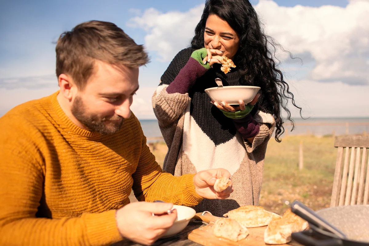 Happy couple eating on sunny beach patio