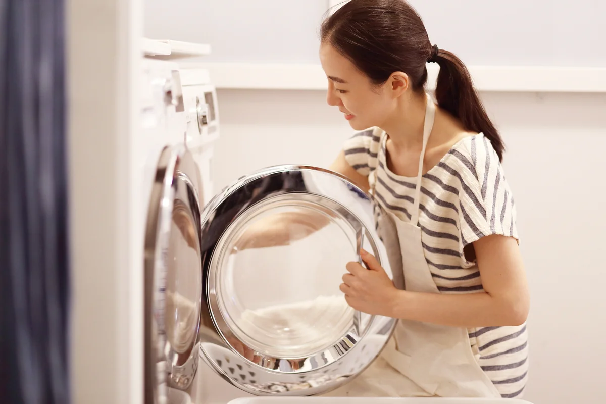 Woman cleaning washing machine