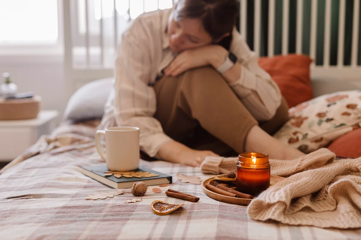 Sad woman sitting on the bed with candle