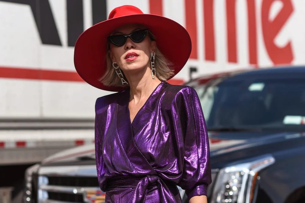 Elegant older woman wearing purple and a red hat