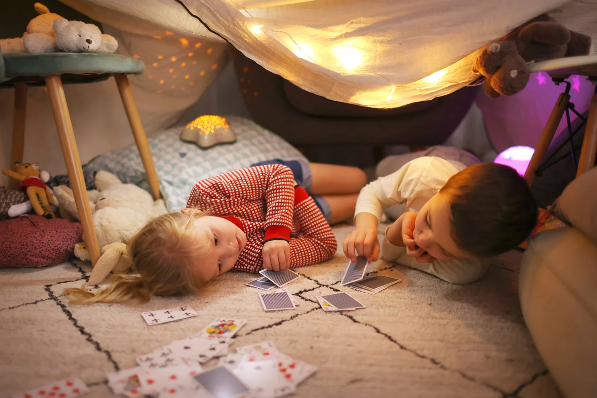 Brother and a sister playing in a homemade illuminated hut