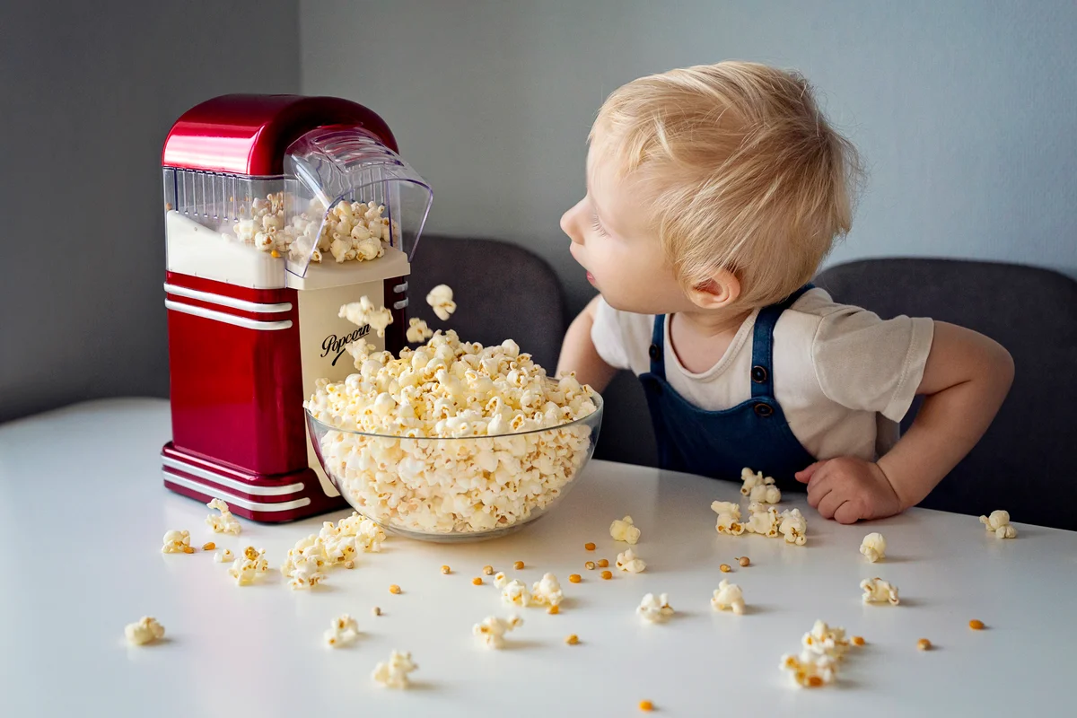 Surprised boy looking at popcorn maker