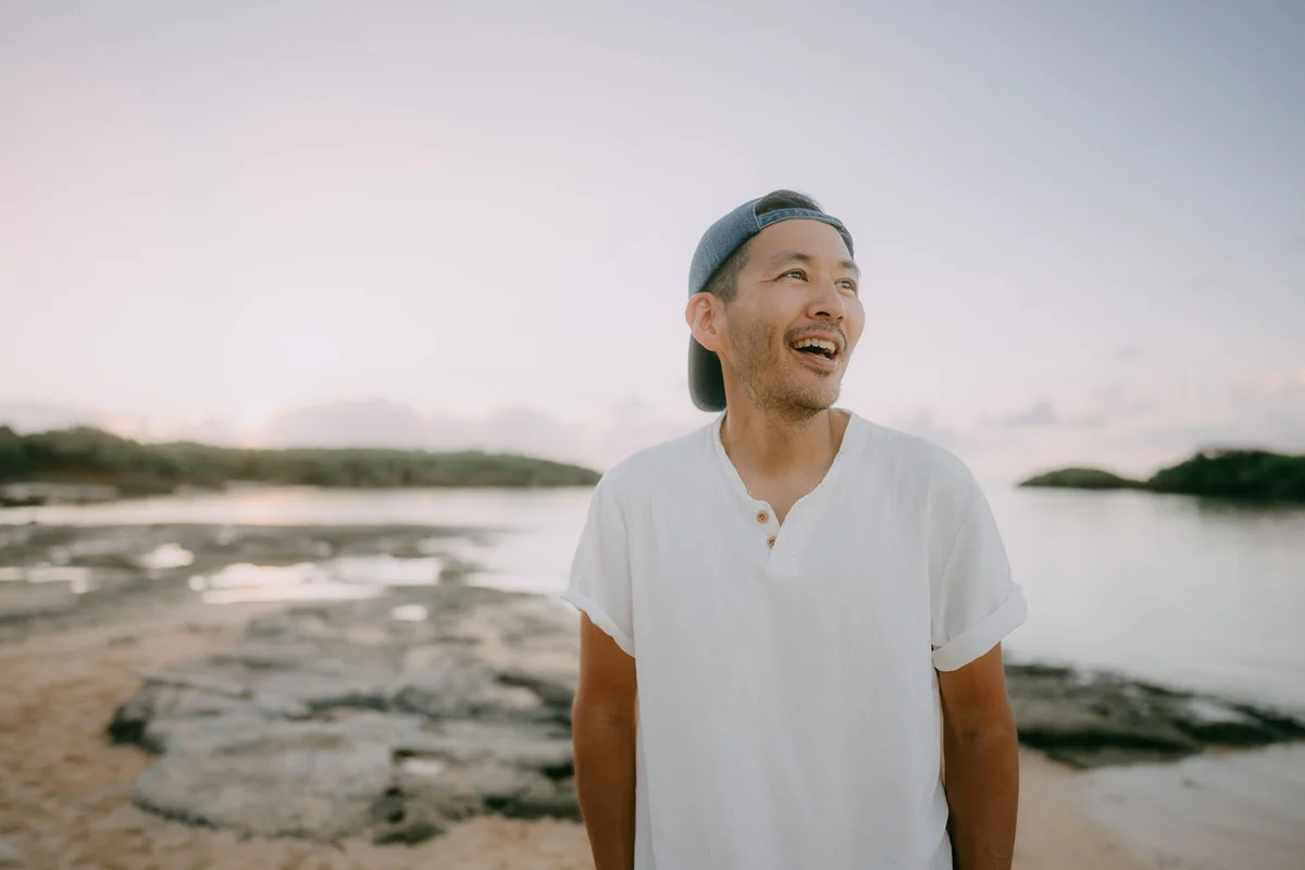 Happy man on beach at sunset -