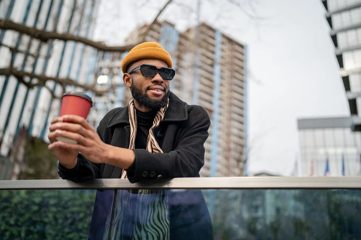 guy holding take away coffee and looking into distance