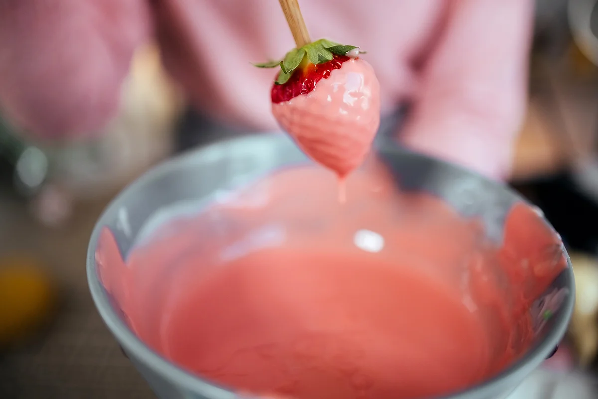 Woman dipping strawberries in chocolate
