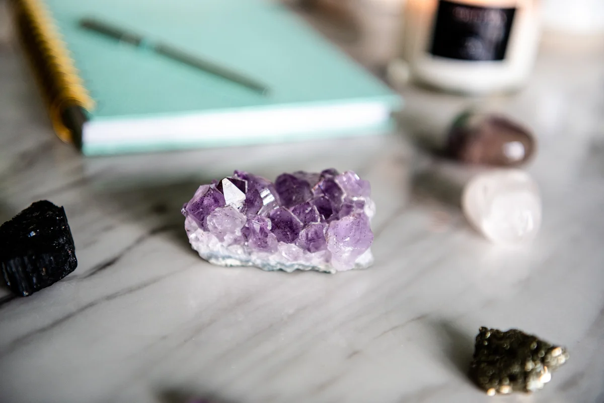 amethyst cluster on a desk with other crystals
