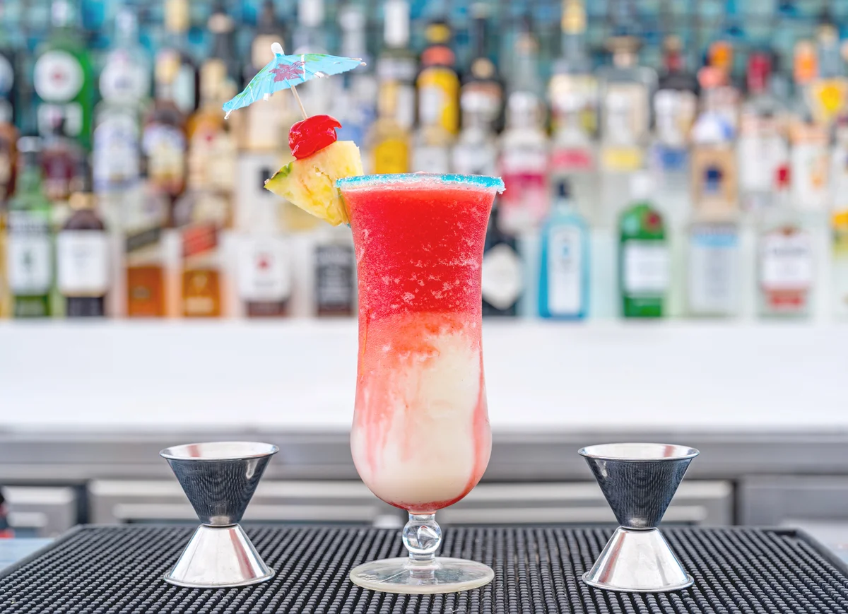 Image of a Miami Vice cocktail sitting on top of a bar.