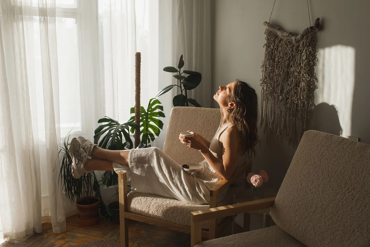 woman drinking morning coffee at cozy sunlight apartment