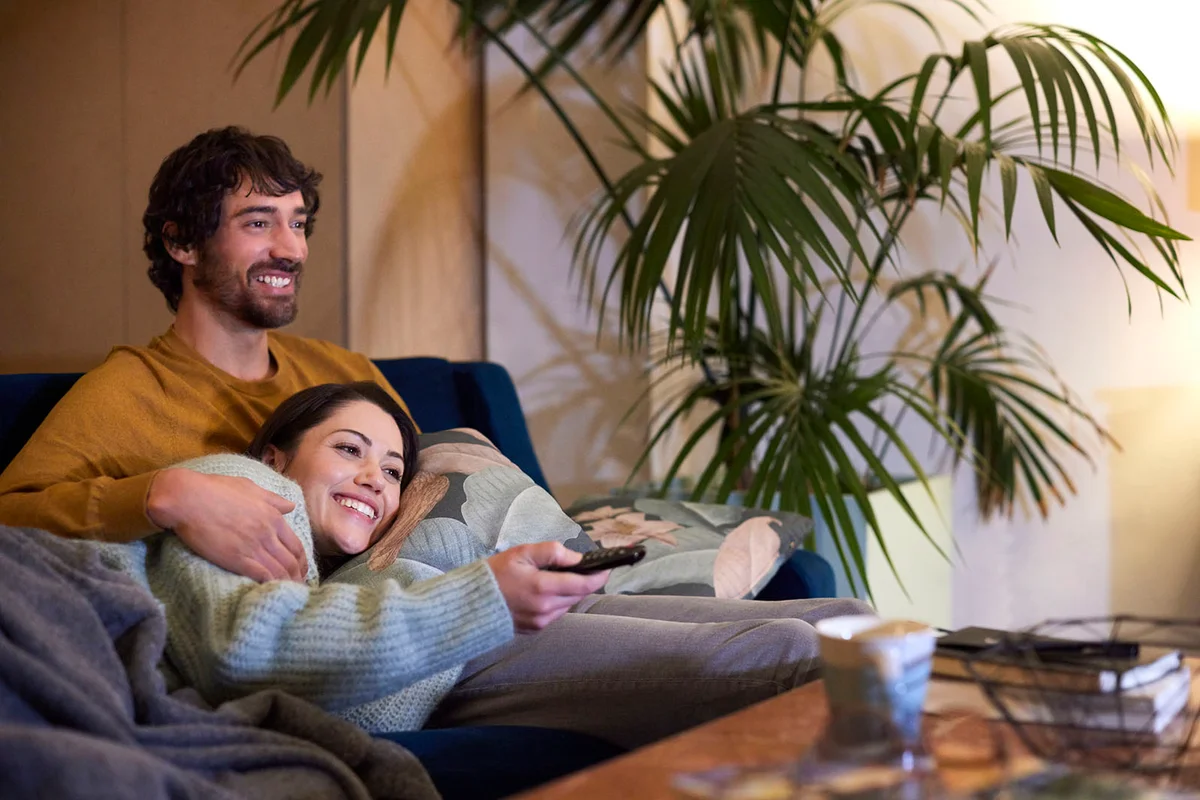 Happy Couple Watching TV At Home