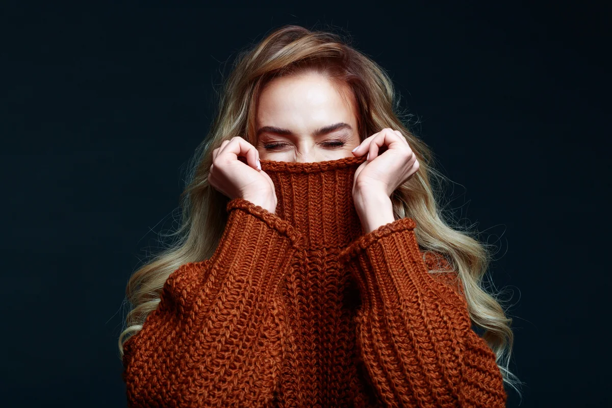 Blond young woman wearing brown sweater