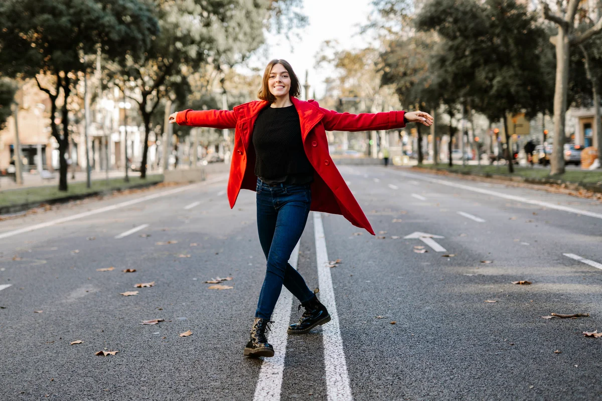 Young woman with arms outstretched on road