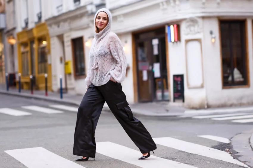 Woman wearing knit pullover with mesh parts and black wide-leg flared pants