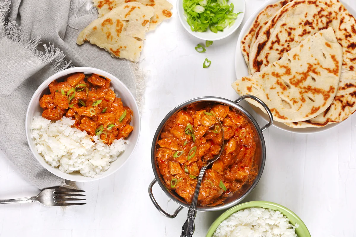 Butter chicken served with rice and flatbread