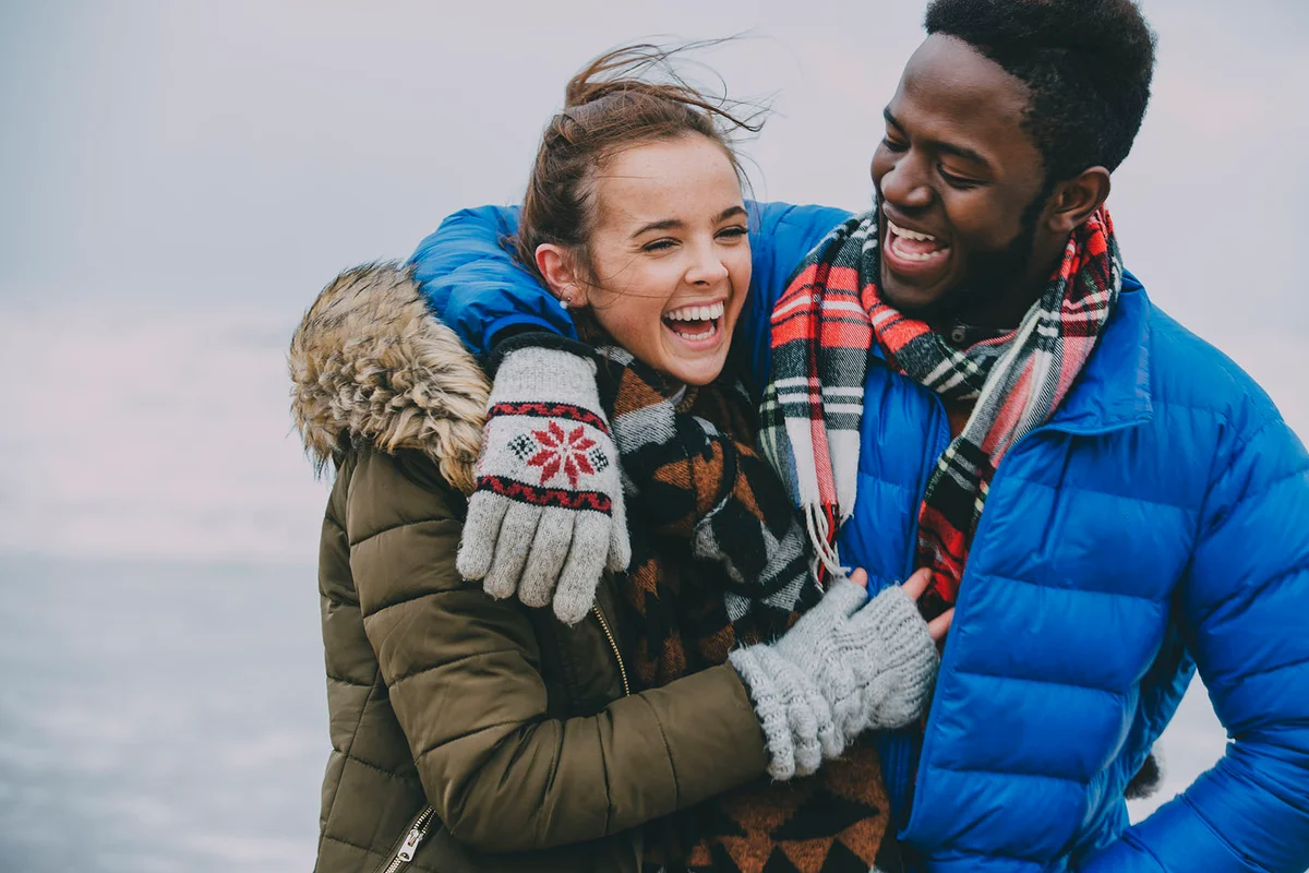 Young Couple Laughing On A Winter Beach