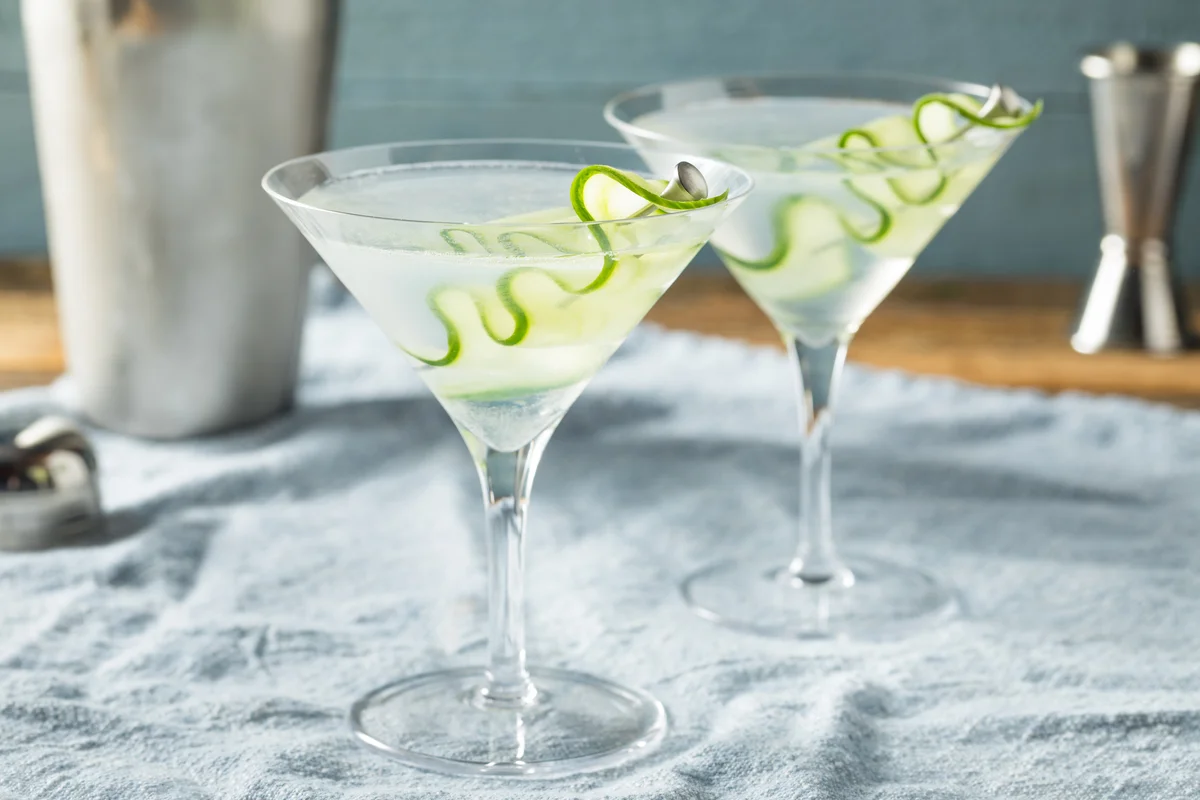 Two cucumber martinis sitting on a table.