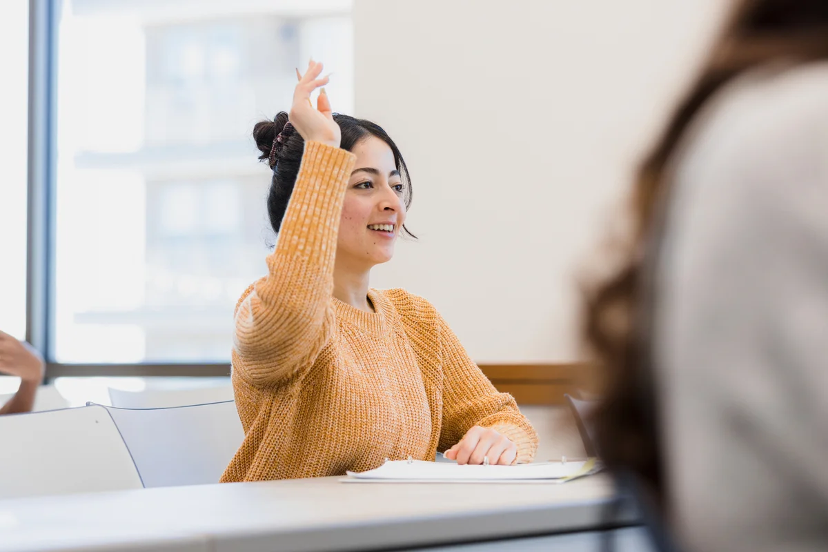 college student raising hand in class
