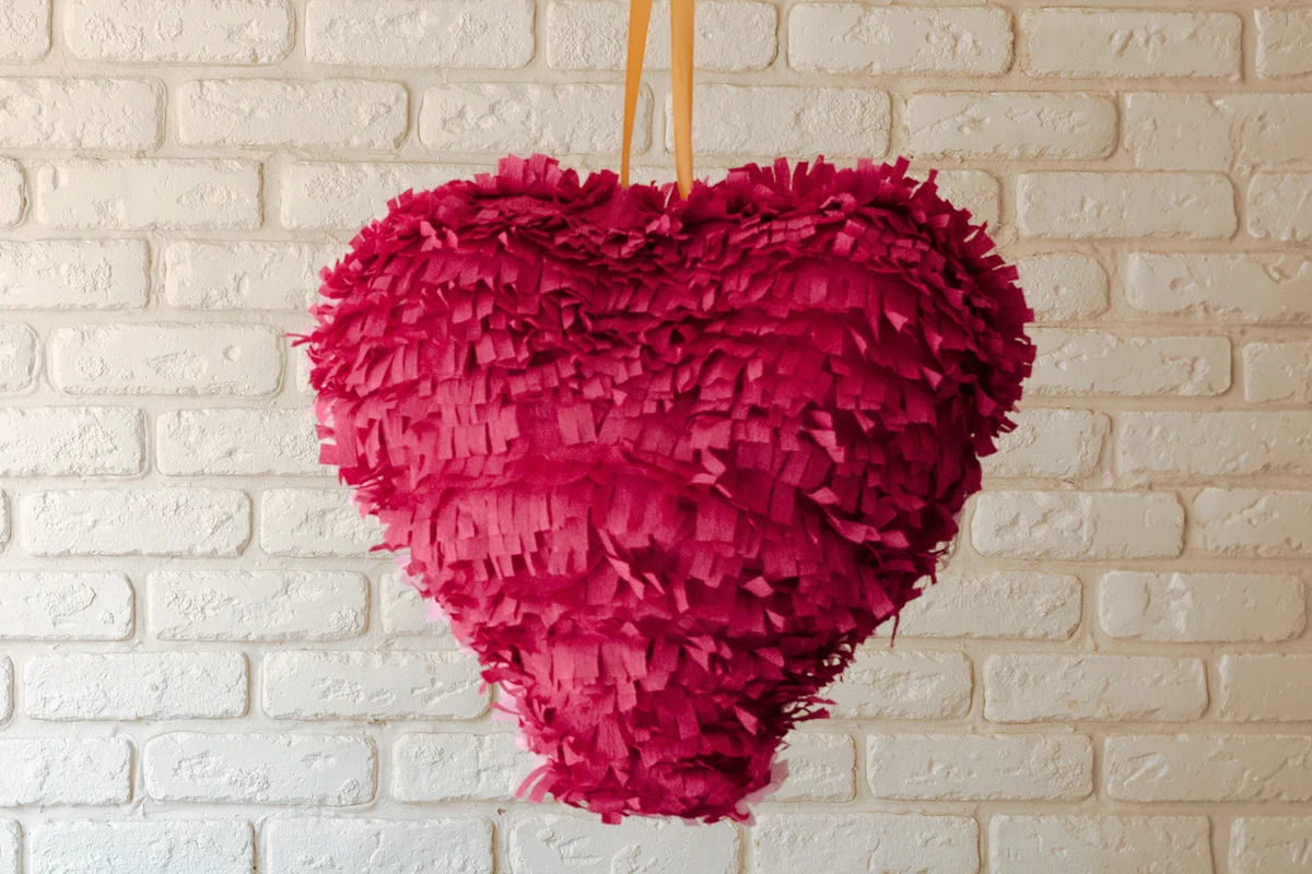 Pink paper heart pinata wait for party