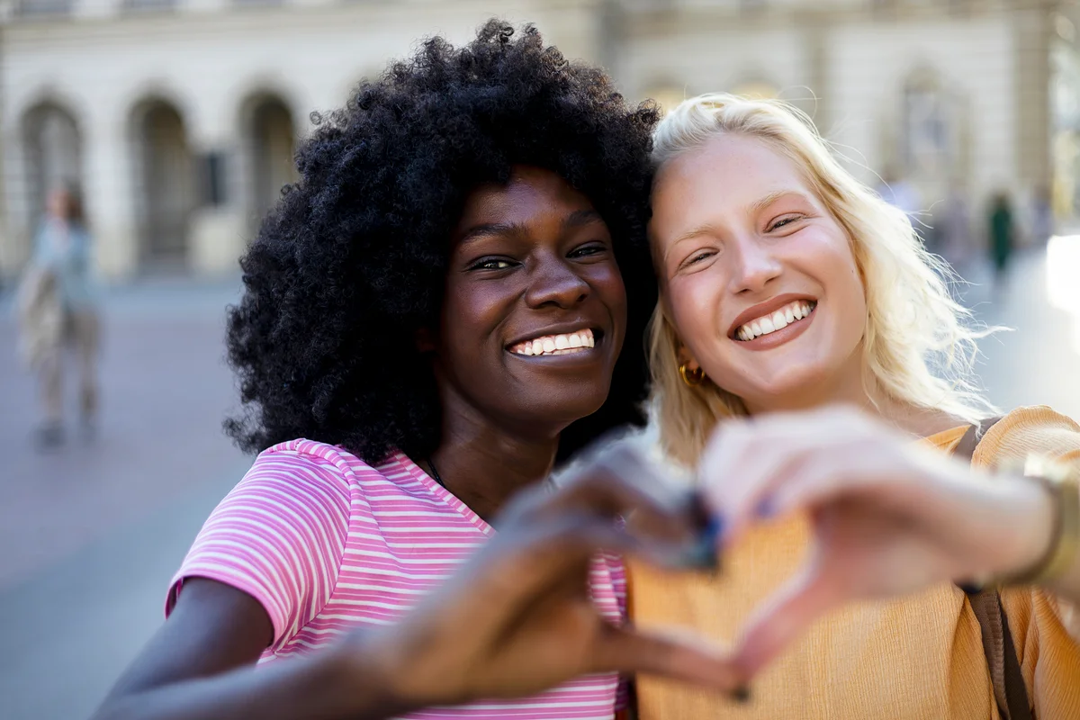 two friends making heart hands