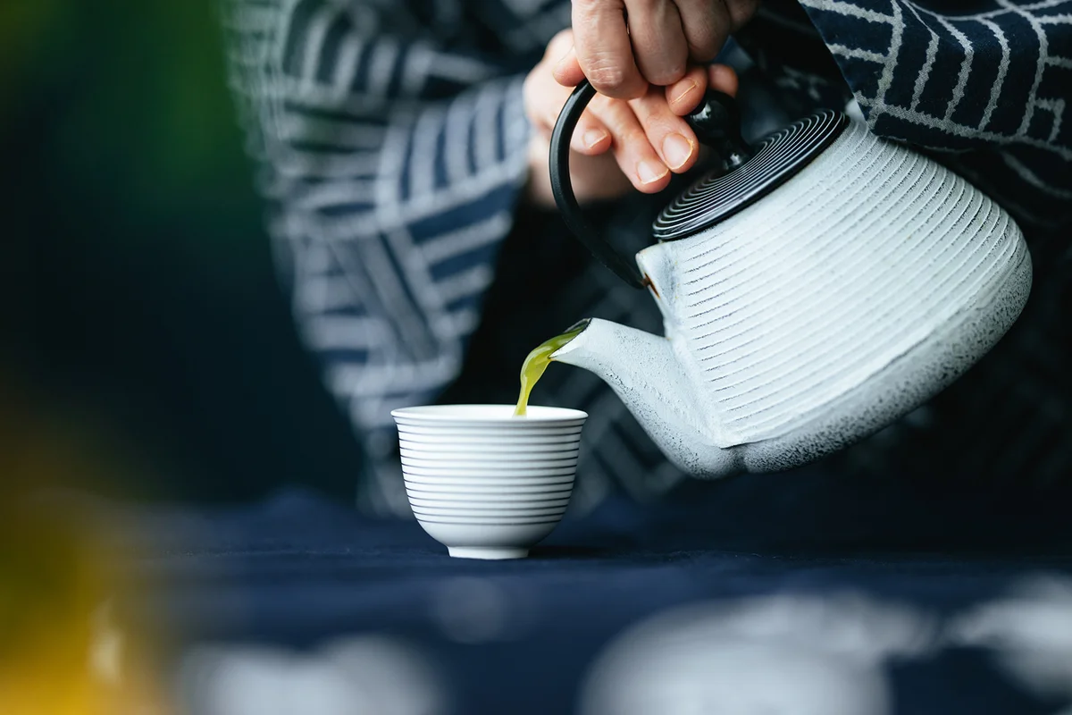 Pouring Matcha Green Tea From Teapot Into A Cup
