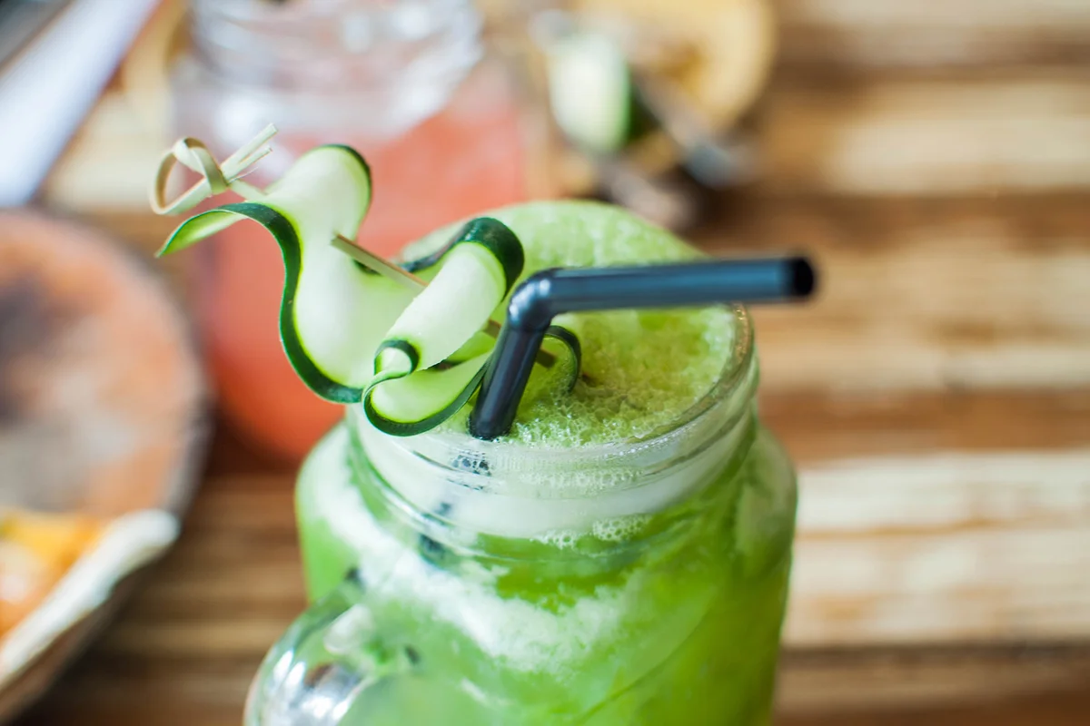 Cold elderflower infused cucumber and lemon juice on a wooden table
