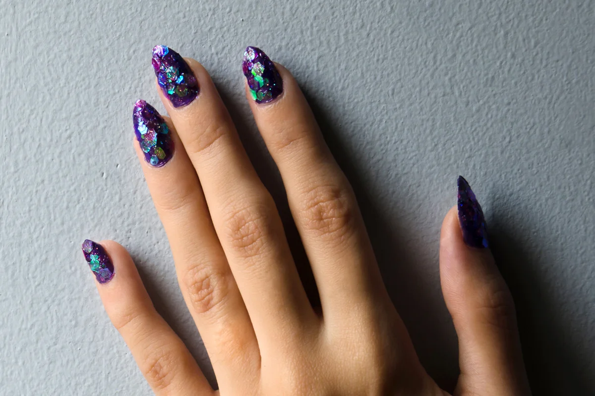 Hand showing purple design nail art