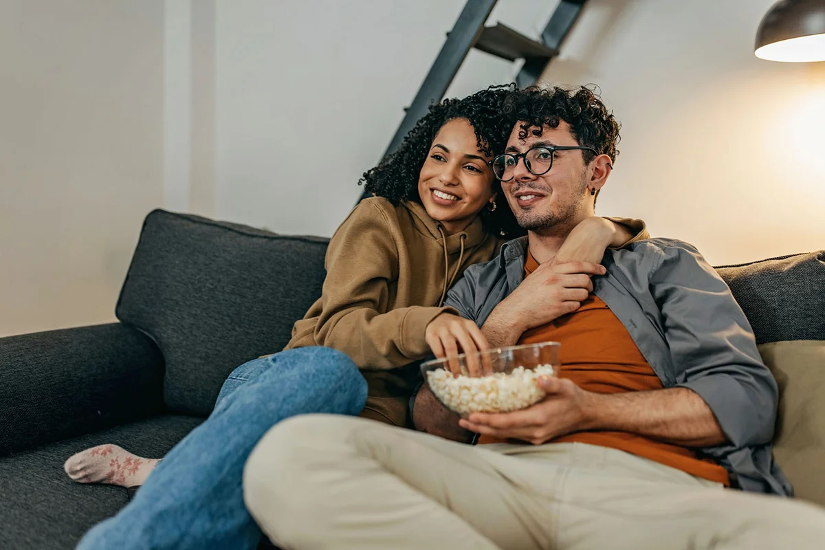 Young couple relaxing at home watching TV