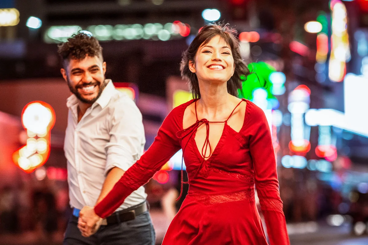 couple holding hands and laughing as they enjoy a night out